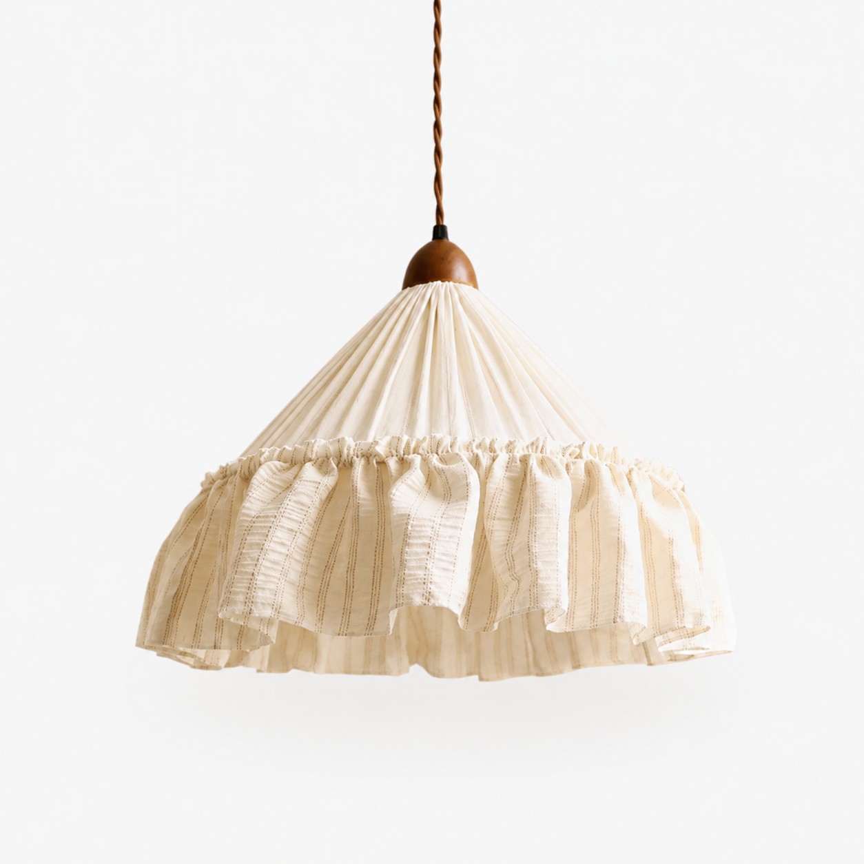 Ruffled fabric pendant beside a French country bed